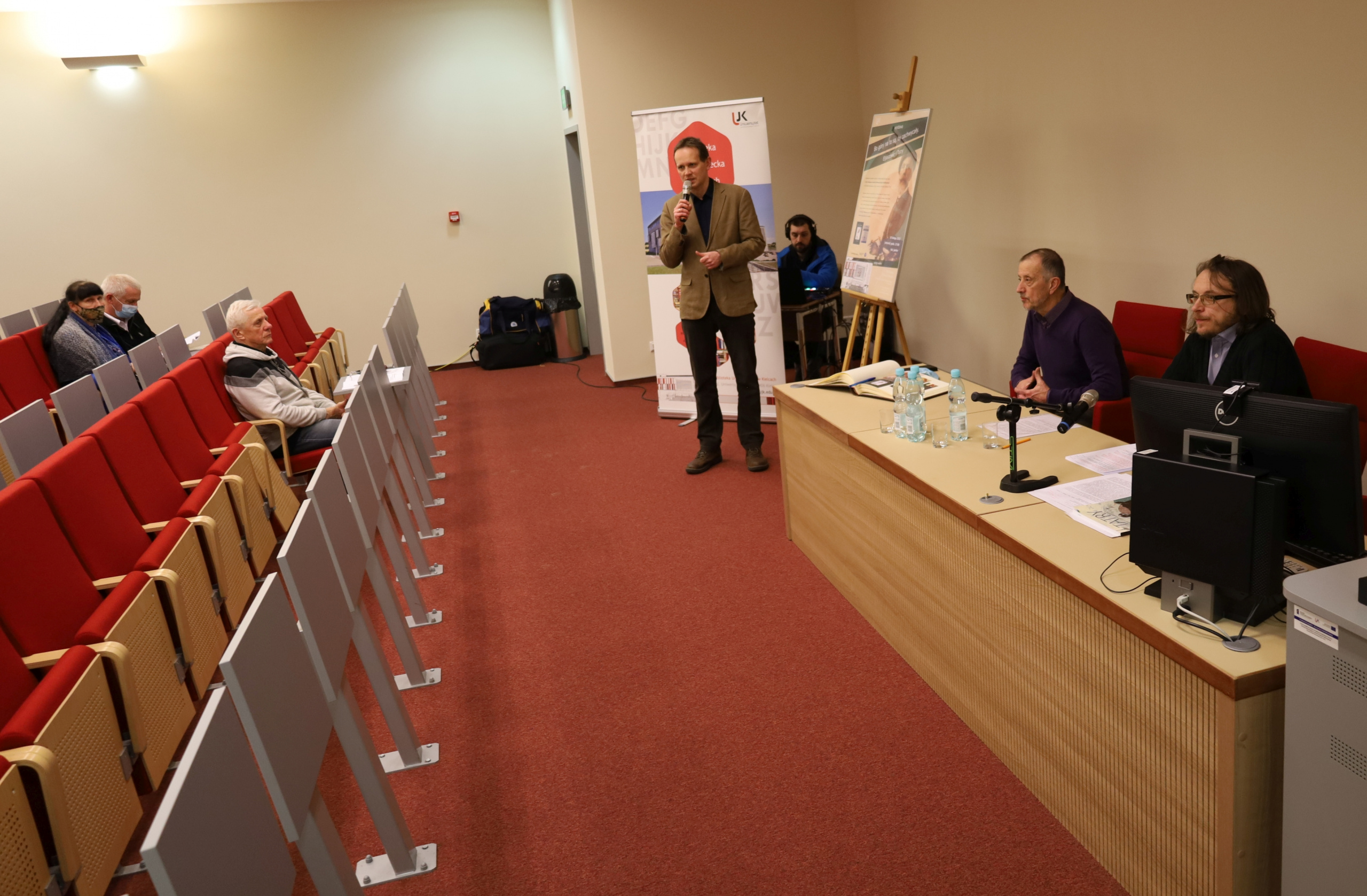 Autor książki i autor wystawy przy stole. Przy mikrofonie Andrzej Antoniak, dyrektor Biblioteki Uniwersyteckiej.