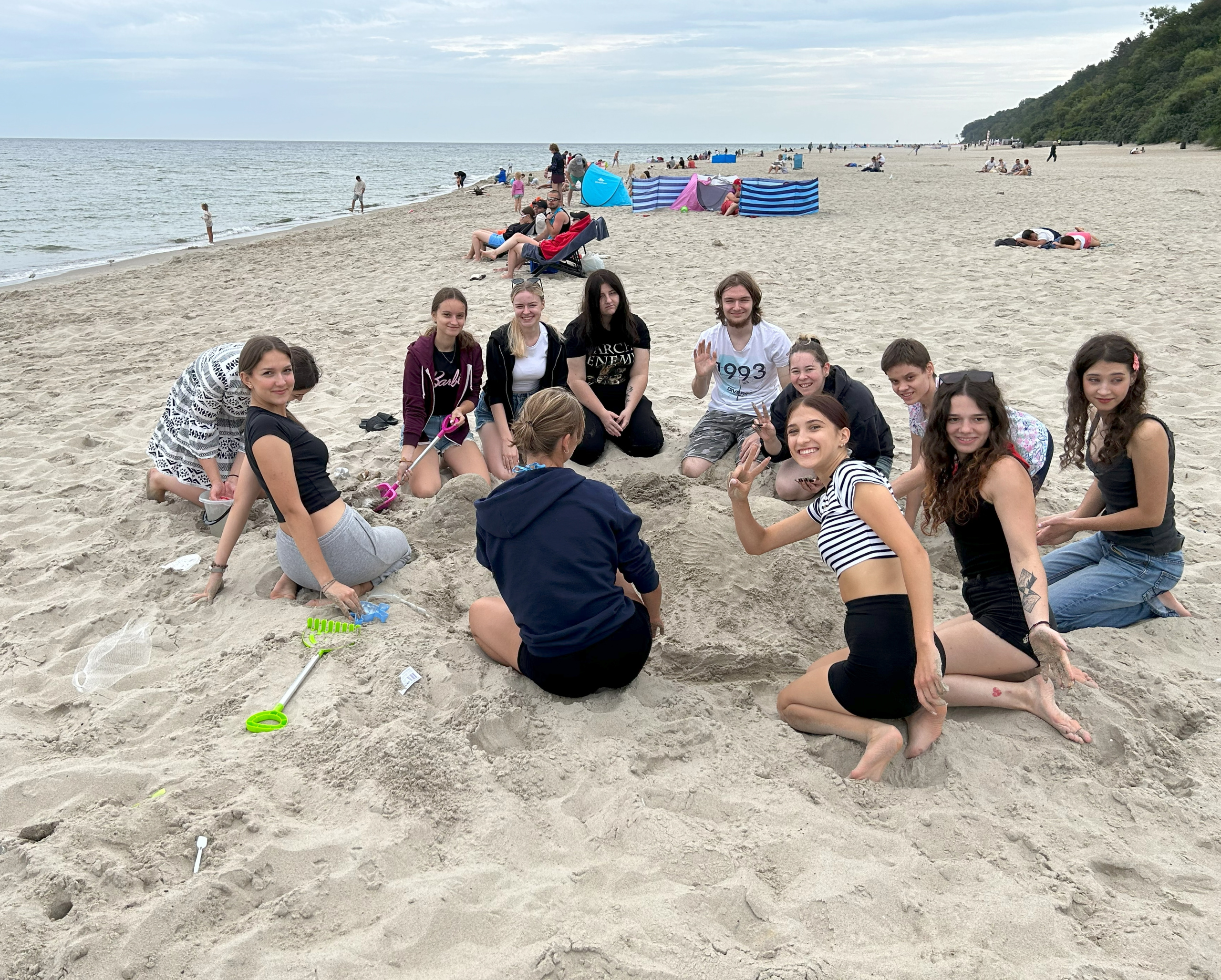 Uczestnicy obozu na plaży w Jastrzębiej Górze robią rzeźby z piasku.
