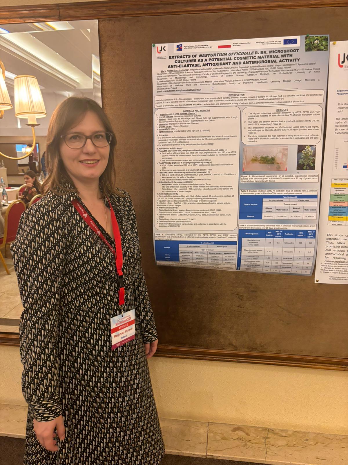 Prof. Małgorzata Wrzosek stoi przy posterach prezentowanych na konferencji.